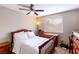 Guest bedroom with dark wood furniture, ceiling fan, and natural light at 8737 Autumn Valley Ave, Las Vegas, NV 89129