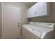 Bright laundry room with a washer, dryer, and cabinet storage at 8737 Autumn Valley Ave, Las Vegas, NV 89129