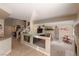 Open-concept living room with tile floors, staircase, fireplace, bar area, and ample natural light at 8737 Autumn Valley Ave, Las Vegas, NV 89129