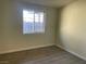 Bedroom with wood-look flooring, large window, and neutral wall color at 1812 Ryan Ave, Las Vegas, NV 89101