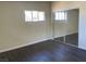 Bedroom with dark wood floors, large window and mirrored closet doors at 1812 Ryan Ave, Las Vegas, NV 89101