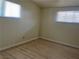 Small bedroom with wood flooring and two windows with blinds at 1812 Ryan Ave, Las Vegas, NV 89101