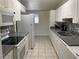Bright kitchen with white appliances, cabinetry, gray countertops, and checkered tile flooring at 1812 Ryan Ave, Las Vegas, NV 89101