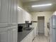 Bright kitchen featuring white cabinets, gray countertops, stainless steel sink, and tile backsplash at 1812 Ryan Ave, Las Vegas, NV 89101