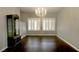 Elegant dining area with a modern chandelier, plantation shutters, and hardwood floors at 427 Norridgewock St, Henderson, NV 89074