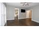 Spacious main bedroom with modern ceiling fan, wood-look tile floors, and access to the main bathroom at 427 Norridgewock St, Henderson, NV 89074