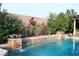 A unique pool features water fountains, brick detailing, desert plants and decorative metal art at 427 Norridgewock St, Henderson, NV 89074