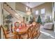 Bright dining room with staircase, chandelier, and a peek into living room and piano at 1590 Sabatini Dr, Henderson, NV 89052