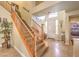 Grand foyer featuring high ceilings, tile flooring, and a staircase with wood railings at 1590 Sabatini Dr, Henderson, NV 89052