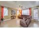 Living room with sectional sofa, large windows, and ceiling fan at 1590 Sabatini Dr, Henderson, NV 89052