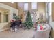 Bright living room with piano, Christmas tree, high ceilings, and elegant neutral-toned furniture at 1590 Sabatini Dr, Henderson, NV 89052