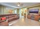 Spacious living room featuring a brown leather sectional sofa and a large flat-screen TV at 1590 Sabatini Dr, Henderson, NV 89052