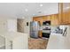 A well-lit kitchen with stainless steel appliances, wooden cabinets, and white countertops at 3023 Sunset Harbor Ct, North Las Vegas, NV 89031