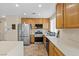 A kitchen with stainless steel appliances, wooden cabinets, and white countertops at 3023 Sunset Harbor Ct, North Las Vegas, NV 89031