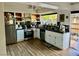 Well-lit kitchen featuring stainless steel appliances, black countertops, white cabinets, and hardwood floors at 3077 Pinehurst Dr # A, Las Vegas, NV 89109