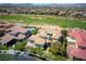 Aerial view of a tile roofed luxury home surrounded by a golf course and mountain views at 1529 Villa Rica Dr, Henderson, NV 89052