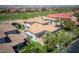 Aerial view of estate with tile roof, manicured lawns, mature trees and golf course in the distance at 1529 Villa Rica Dr, Henderson, NV 89052