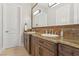 Bathroom featuring dual sinks, granite countertops, custom cabinetry, and decorative mirrors at 1529 Villa Rica Dr, Henderson, NV 89052