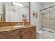 Bathroom with a large framed mirror, granite countertop, custom cabinetry, a toilet, and a shower at 1529 Villa Rica Dr, Henderson, NV 89052