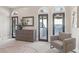 Bright bedroom with nine drawer dresser, arched French doors, accent chair, and neutral color palette at 1529 Villa Rica Dr, Henderson, NV 89052