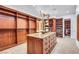 A large walk-in closet featuring custom wood shelving and a central island with a stone countertop at 1529 Villa Rica Dr, Henderson, NV 89052