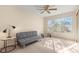 Bright bedroom featuring a futon, ceiling fan, and sunlit window with vertical blinds at 3425 E Russell Rd # 240, Las Vegas, NV 89120