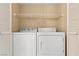 Laundry room with a modern white washer and dryer, plus an open shelf at 3425 E Russell Rd # 240, Las Vegas, NV 89120