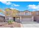 Two-story house with a beige exterior, two-car garage, and landscaping at 5484 Oatfield St, North Las Vegas, NV 89081