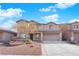 Two-story house with a beige exterior, two-car garage, and landscaping at 5484 Oatfield St, North Las Vegas, NV 89081