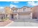 Two-story house with a beige exterior, two-car garage, and landscaping at 5484 Oatfield St, North Las Vegas, NV 89081