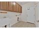 Laundry room with upper cabinets, sink, and tiled floor at 5484 Oatfield St, North Las Vegas, NV 89081