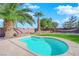 Relaxing kidney-shaped pool surrounded by a well-manicured lawn and palm trees at 5484 Oatfield St, North Las Vegas, NV 89081