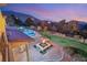 Landscaped backyard oasis with fire pit and pool at 62 Golf Estates Dr, Las Vegas, NV 89141