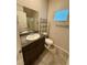 Bathroom featuring a granite vanity, a large mirror, and a toilet with chrome accessories with natural light at 7544 Pink Mimosa Ave, Las Vegas, NV 89113