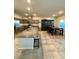 Kitchen featuring granite counters, a stainless refrigerator, an island with barstool seating, and an adjacent dining area at 7544 Pink Mimosa Ave, Las Vegas, NV 89113