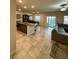 Open floor plan kitchen with island, dark wood accents, tile floors and view to an adjacent living space at 7544 Pink Mimosa Ave, Las Vegas, NV 89113