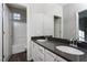 Bathroom with double vanity, dark countertop, and shower/tub combo at 9936 Coyote Echo Ct, Las Vegas, NV 89166