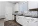 White kitchen with gray counters and stainless steel appliances at 9936 Coyote Echo Ct, Las Vegas, NV 89166