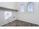 Laundry room with upper shelving, wood-look flooring, and arched windows at 9936 Coyote Echo Ct, Las Vegas, NV 89166