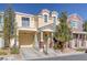 Charming yellow two-story home with a balcony, attached garage and landscaped front yard at 1676 Tristan Flower Ave, Las Vegas, NV 89183