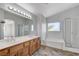 Bright bathroom featuring a double sink vanity, large mirror, soaking tub, and glass-enclosed shower at 4788 Frankfurt Ct, Las Vegas, NV 89147