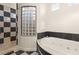 Modern bathroom features a soaking tub, separate shower, and a glass block window at 1282 Calcione Dr, Henderson, NV 89011