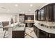 Gourmet kitchen featuring dark wood cabinets, granite countertops, and stainless steel appliances at 1282 Calcione Dr, Henderson, NV 89011