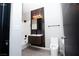 Bathroom with modern vanity with wood-look accent wall, toilet, and tub with white tile surround at 2151 Hussium Hills St # 207, Las Vegas, NV 89108