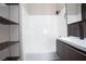 Bathroom featuring tub with white tile surround, modern vanity and dark wood-look shelving at 2151 Hussium Hills St # 207, Las Vegas, NV 89108