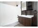 Bathroom with modern vanity with wood-look accent wall, and tub with white tile surround at 2151 Hussium Hills St # 207, Las Vegas, NV 89108