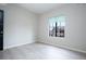 Neutral-toned bedroom features a window with exterior views and light, modern flooring at 2151 Hussium Hills St # 207, Las Vegas, NV 89108