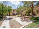 Exterior view of community picnic area with seating surrounded by mature trees and manicured lawns at 2151 Hussium Hills St # 207, Las Vegas, NV 89108