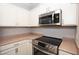 White cabinets complement stainless steel microwave and electric range at 2151 Hussium Hills St # 207, Las Vegas, NV 89108