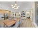 Open concept dining room with a long wooden table and modern light fixture at 4660 Fiore Bella Blvd, Las Vegas, NV 89135